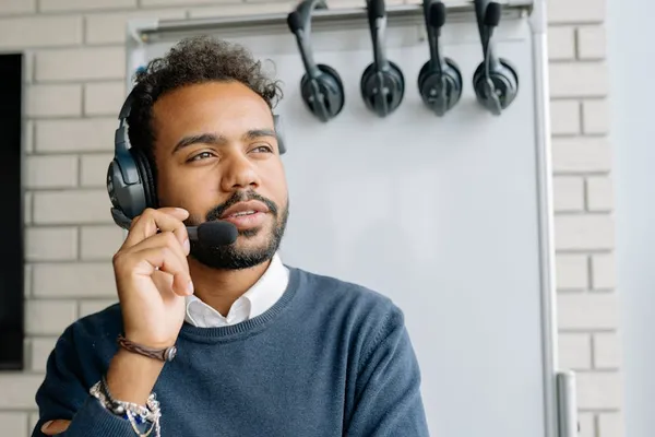 A Singapore customer service professional staying calm at a service counter while listening attentively to an upset customer, with a colleague nearby for support