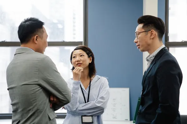 A Singapore professional practising a structured monologue with a phone on a tripod recording, focused expression, deliberate practice in a quiet room