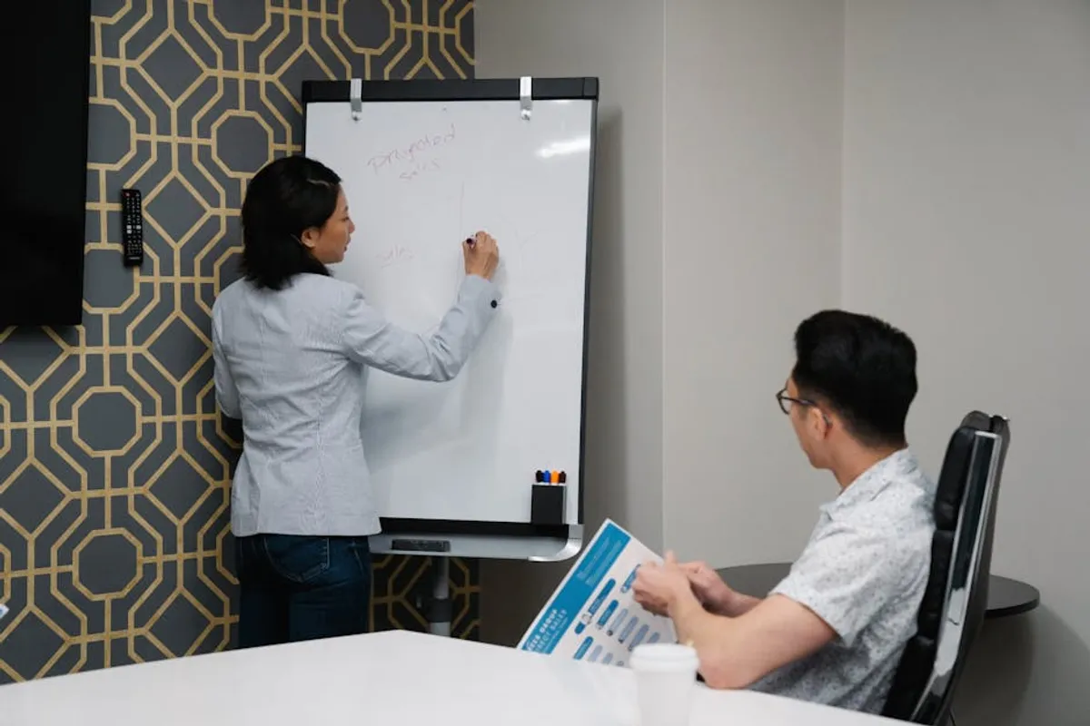 A Singapore presenter at the front of a meeting room mid-opening, audience attentive in the first 30 seconds, single slide visible behind