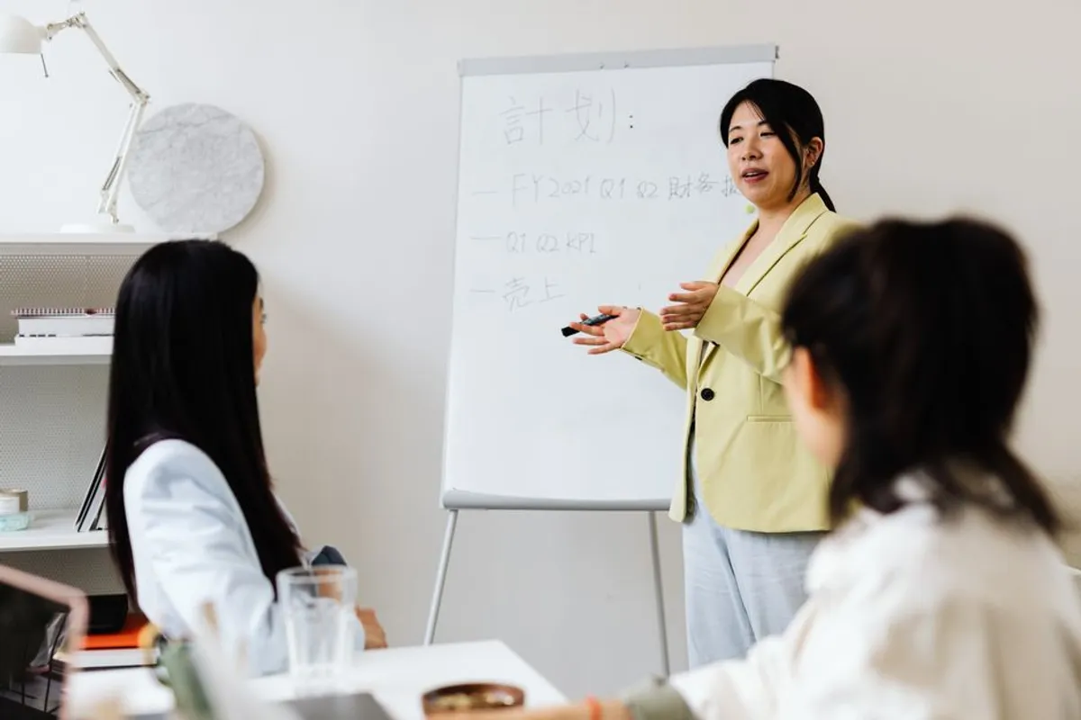 A Singapore business professional standing beside a screen mid-presentation, structured slides visible, audience engaged in a meeting room