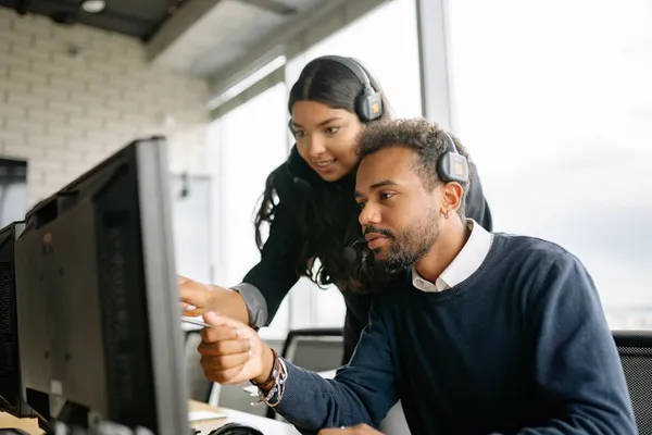 A Singapore customer service agent carefully drafting a reply email at a clean workstation, headset around neck, focused composition