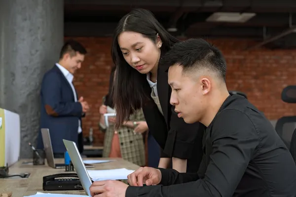 A Singapore professional drafting a formal email to their manager at a clean desk, screen visible, careful posture, considered tone