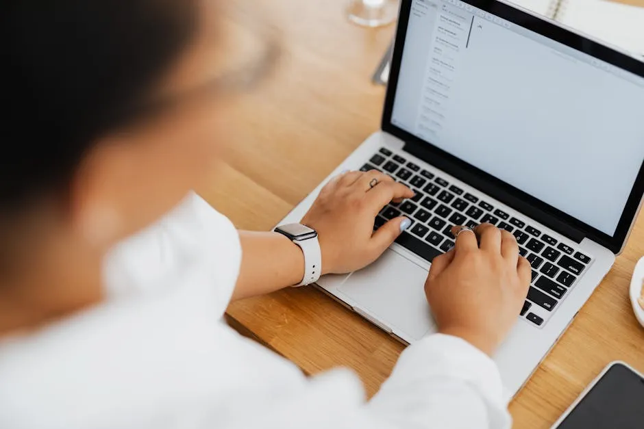 A professional in a Singapore office composing a structured email — visible draft on screen, calm and focused workspace